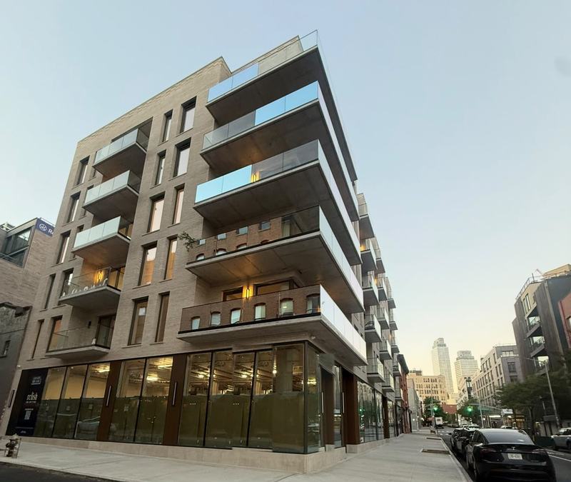 The finished mixed-use building at golden hour with its new sidewalk — Platinum Concrete NY project