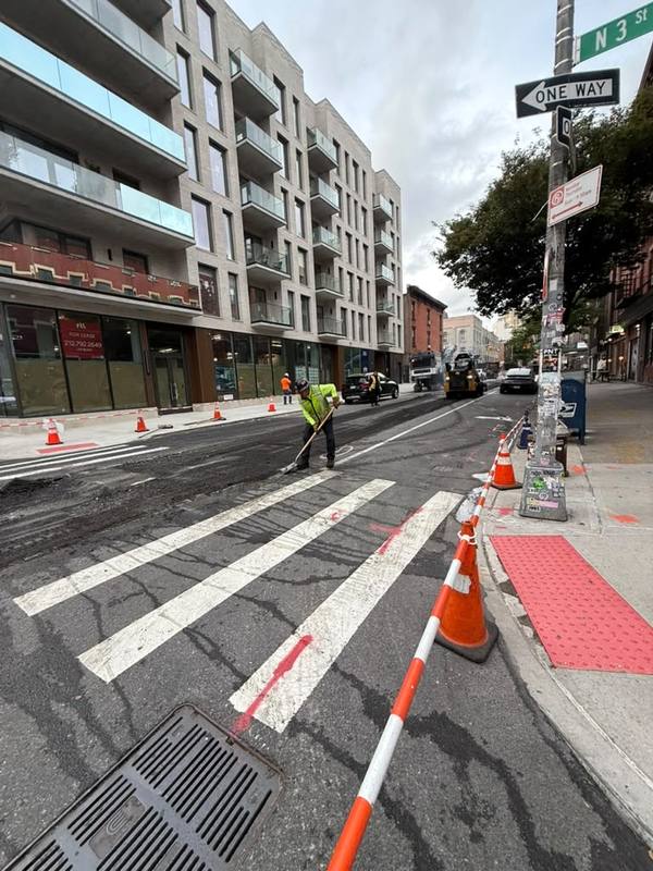 Crew raking fresh asphalt at the crosswalk — Platinum Concrete NY