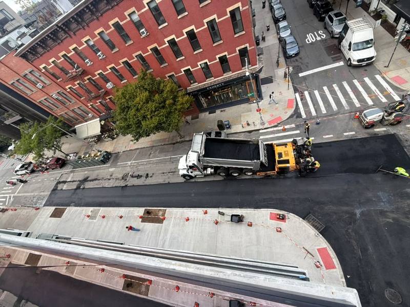 Aerial view of the paver and dump truck laying fresh asphalt — Platinum Concrete NY