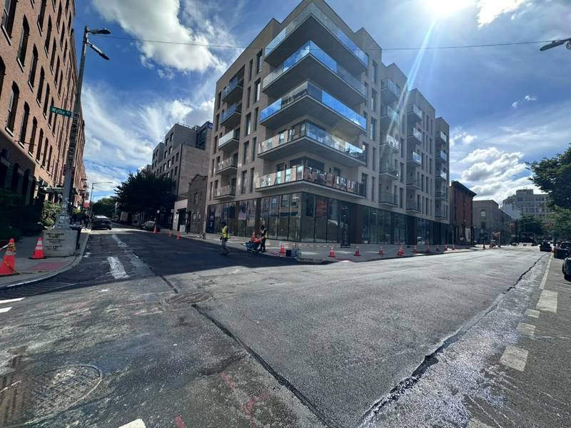 Finished corner with fresh asphalt and the completed building — Platinum Concrete NY