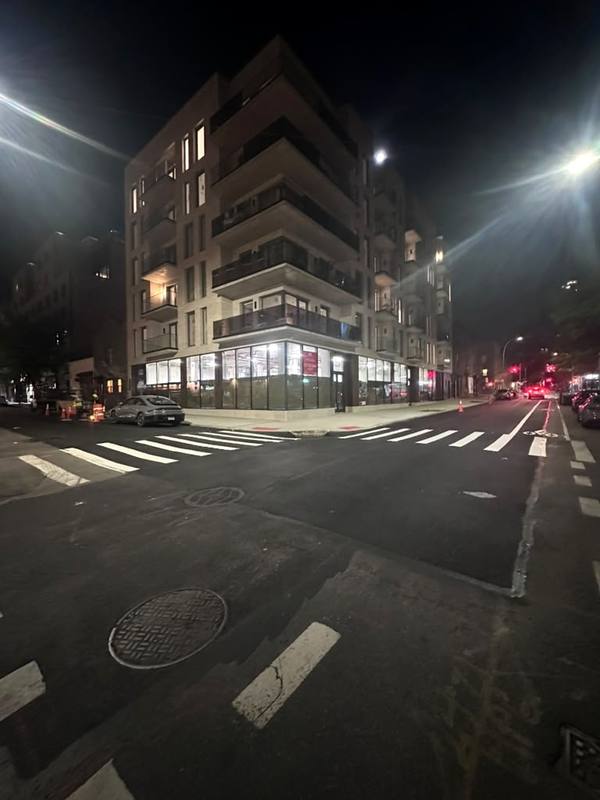 The finished corner at night with fresh crosswalk striping — Platinum Concrete NY
